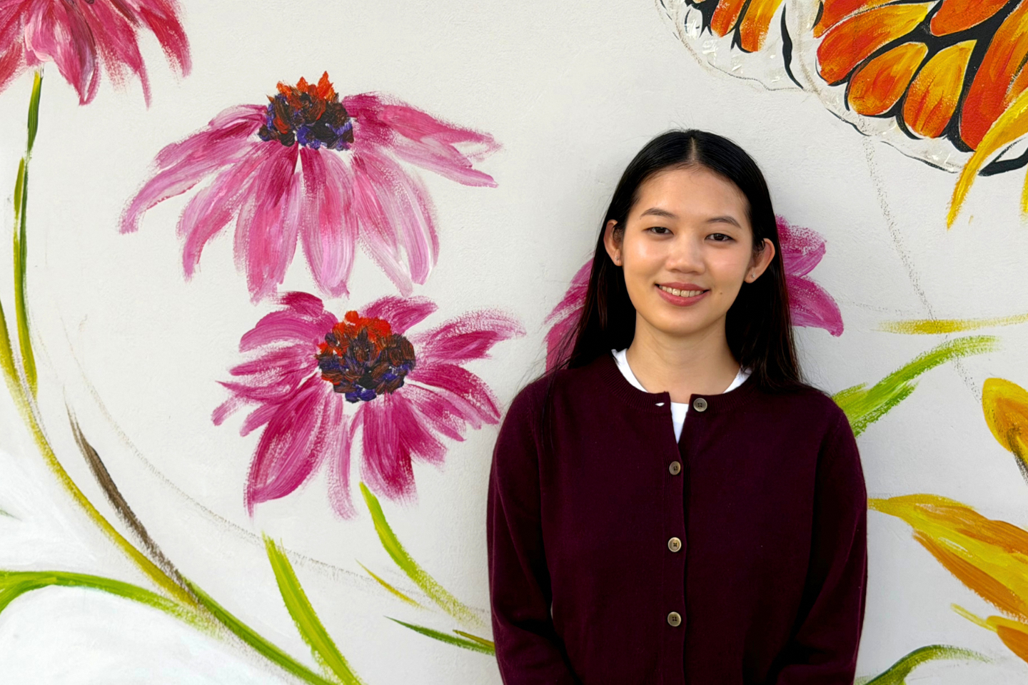 Girl placing smiling, with a floral background